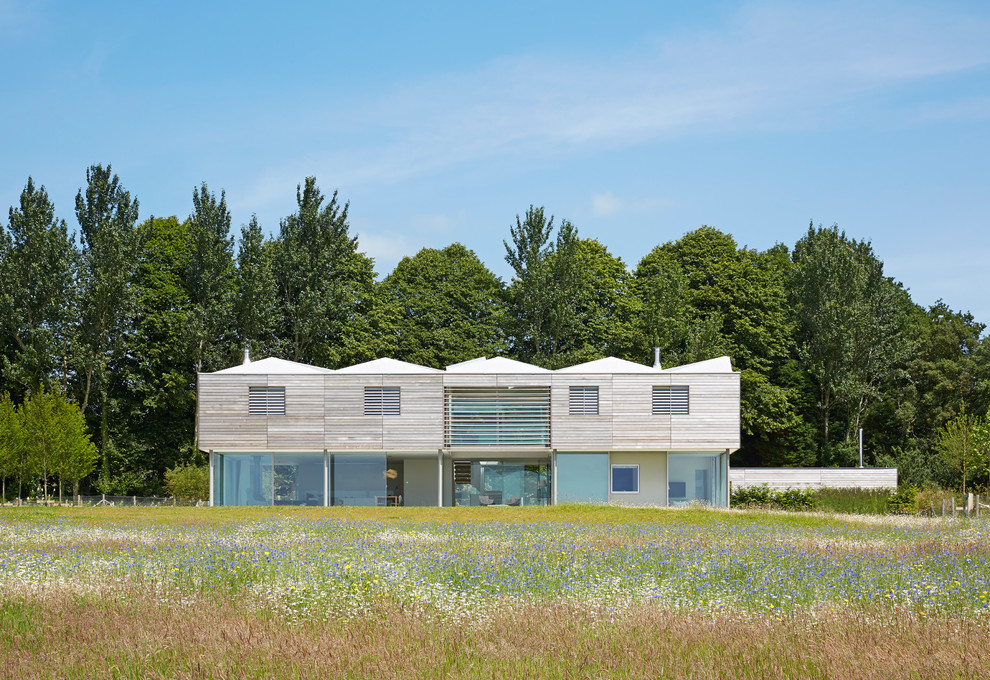 Idee per la villa grande beige moderna a due piani con rivestimento in legno, tetto a farfalla, copertura mista, tetto grigio e pannelli e listelle di legno