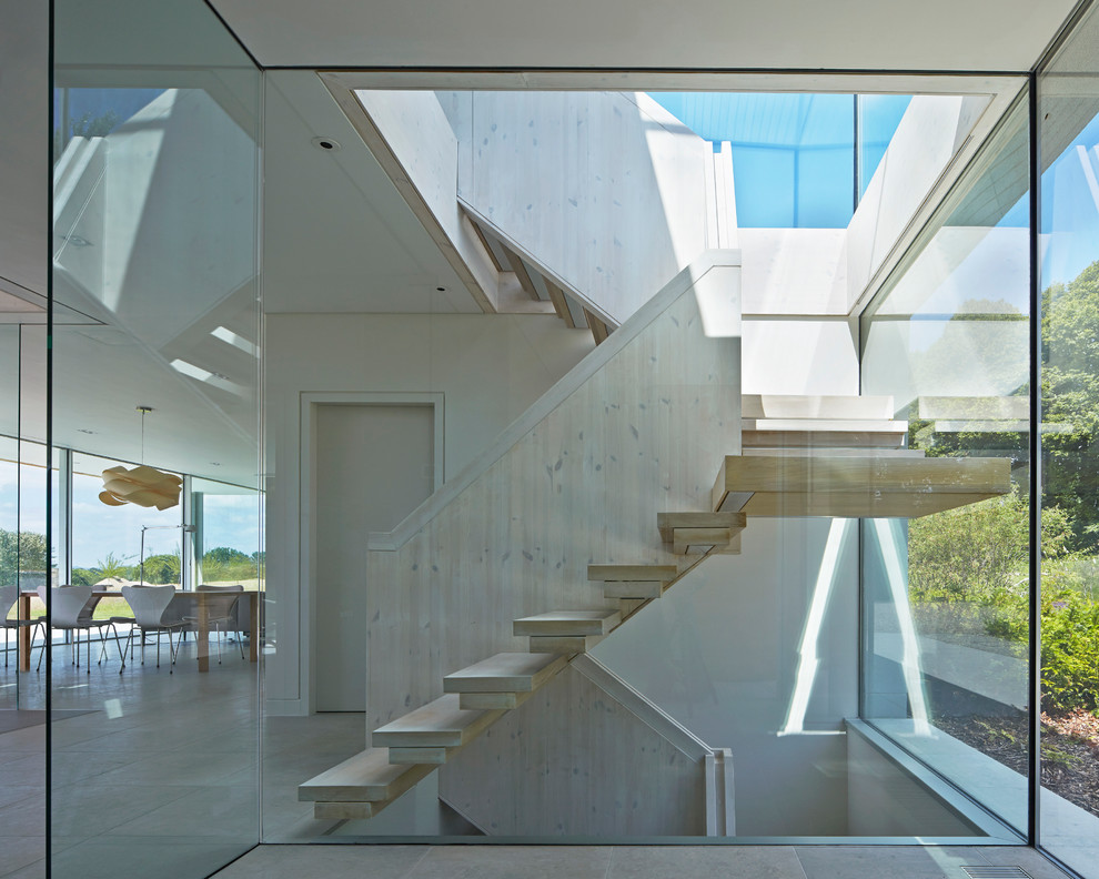 На фото: п-образная лестница среднего размера в стиле модернизм с деревянными ступенями и деревянными перилами без подступенок с