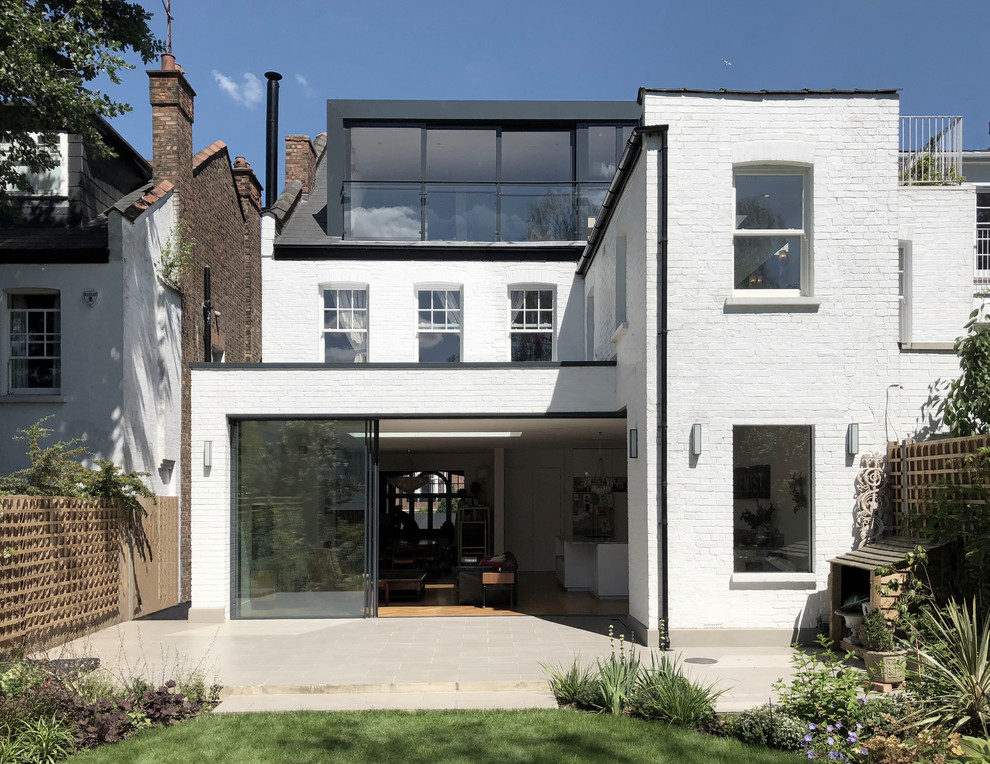 Imagen de fachada de casa bifamiliar blanca contemporánea grande de tres plantas con revestimiento de ladrillo
