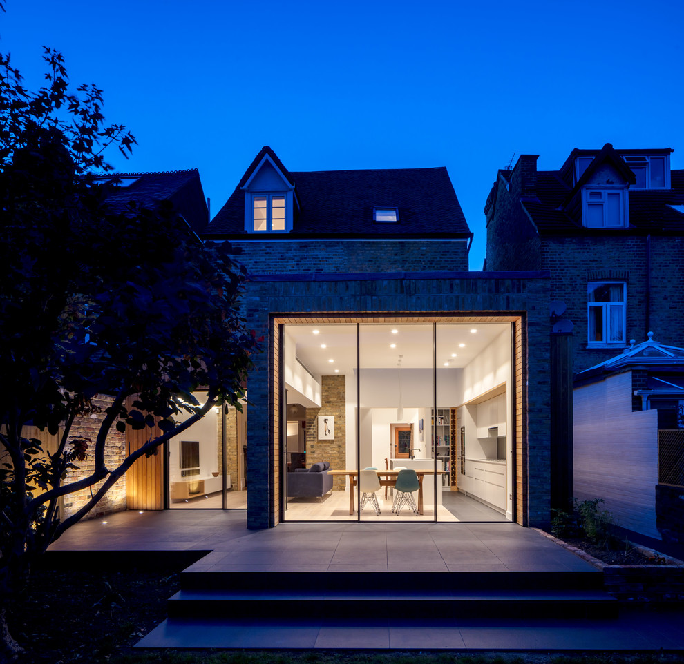 Mittelgroße, Einstöckige Moderne Doppelhaushälfte mit Backsteinfassade, bunter Fassadenfarbe, Flachdach und Schindeldach in London