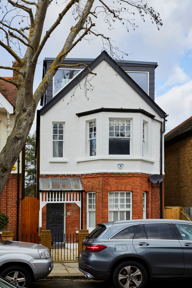 Medium sized and red modern house exterior in London with three floors, a half-hip roof and a tiled roof.