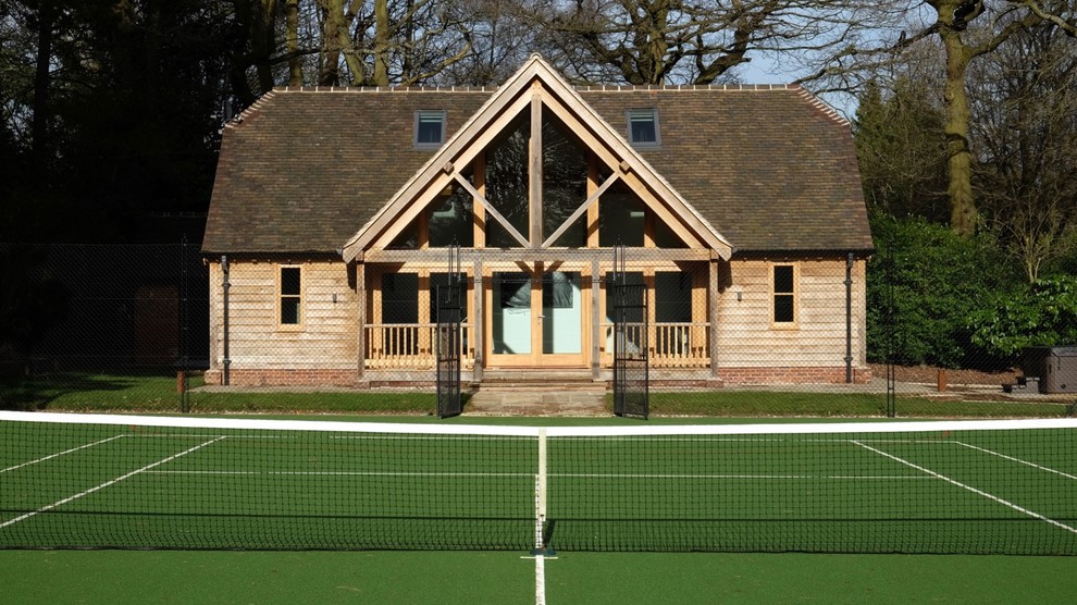 Cette image montre une façade de maison beige traditionnelle en bois de taille moyenne et de plain-pied avec un toit à deux pans et un toit en tuile.