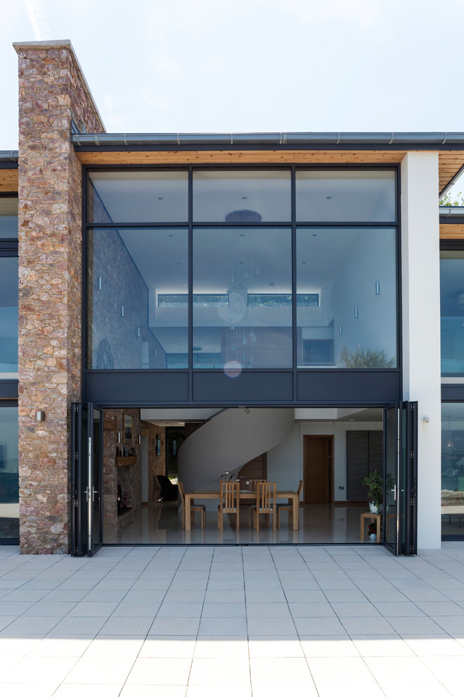 Cette image montre une façade de maison design à un étage avec un revêtement mixte et un toit plat.