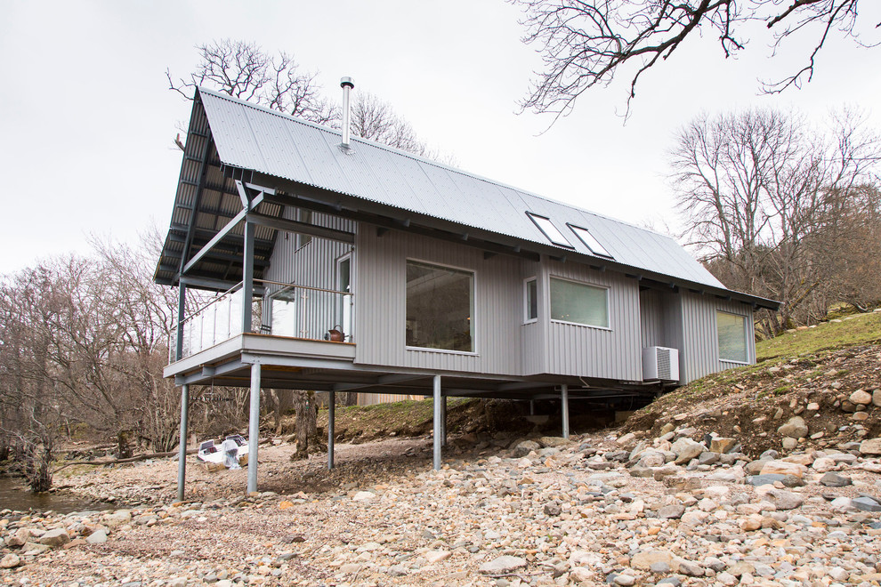 Idées déco pour une petite façade de maison métallique et grise bord de mer de plain-pied avec un toit à deux pans.