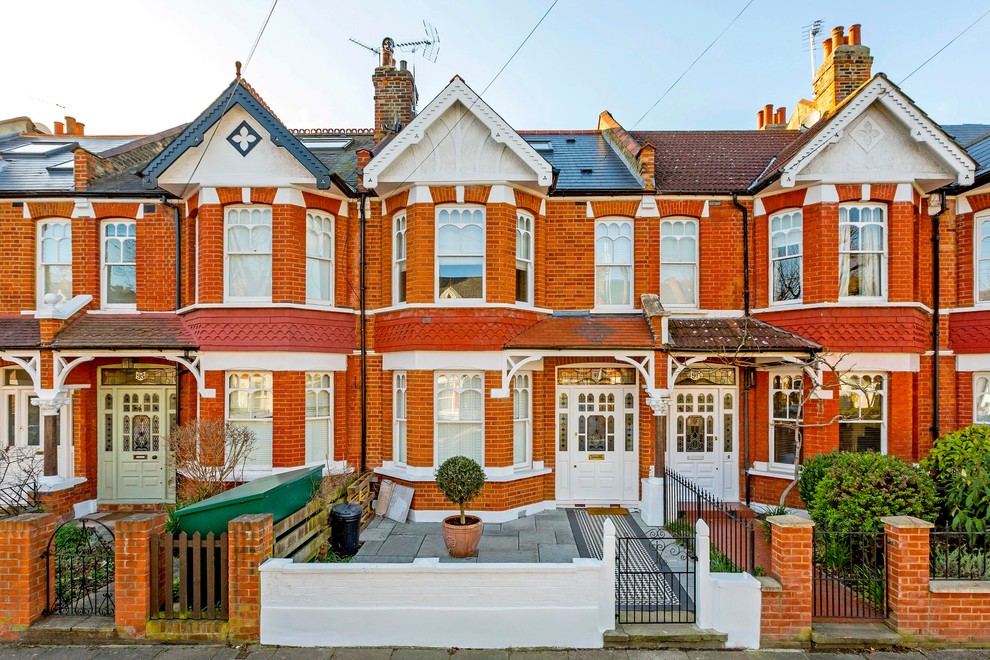 Zweistöckiges Klassisches Einfamilienhaus mit Backsteinfassade, roter Fassadenfarbe und Satteldach in London