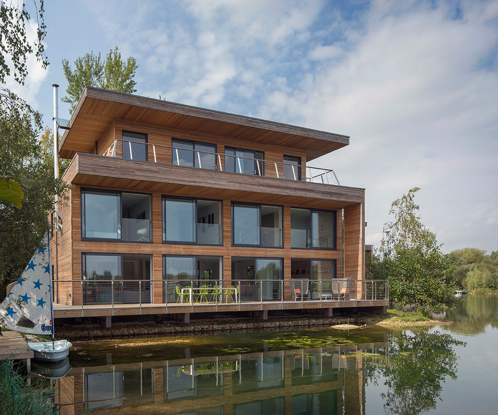 Идея дизайна: трехэтажный, деревянный, коричневый дом в современном стиле с плоской крышей