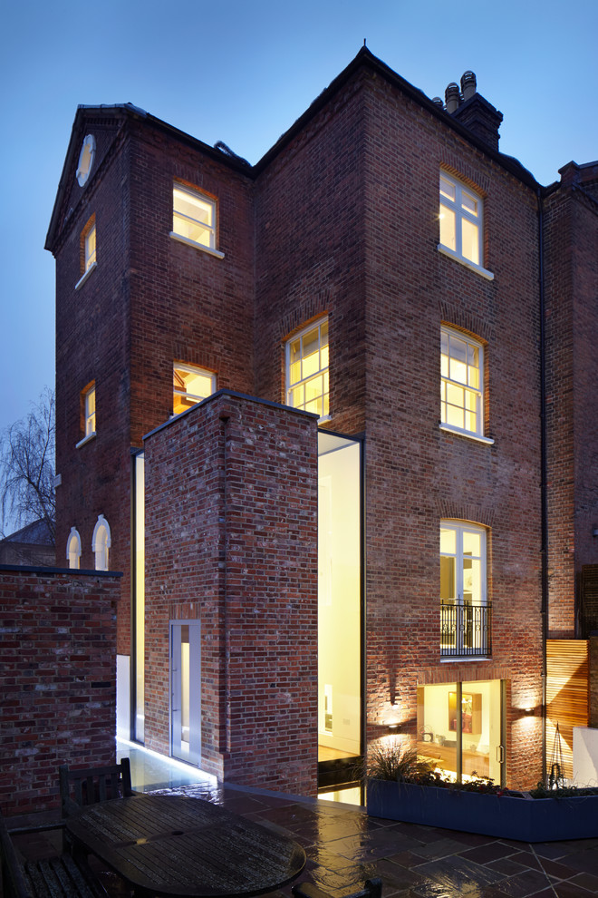 Photo of a red classic brick house exterior in London with three floors.