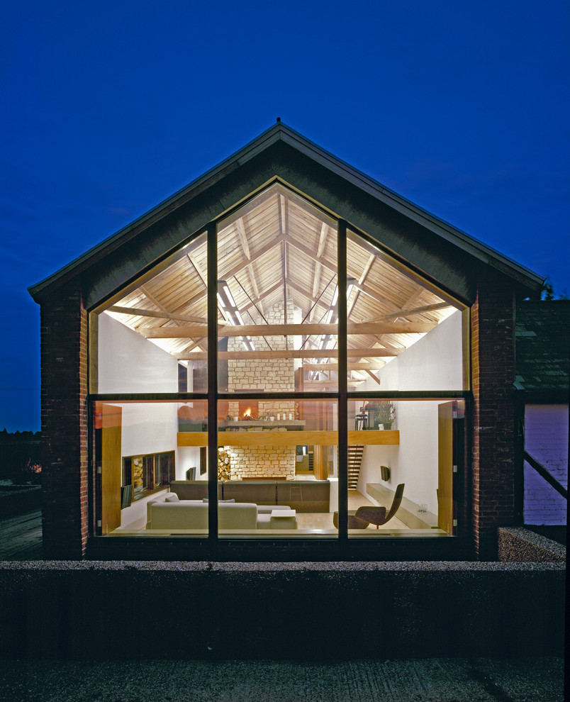 Exempel på ett modernt hus, med allt i ett plan, glasfasad och sadeltak