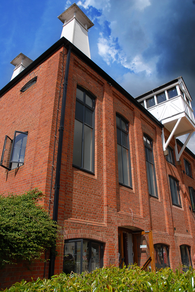 Photo of a large and red industrial brick house exterior in Buckinghamshire with three floors.