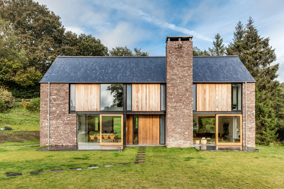 Inspiration pour une façade de maison design à un étage avec un revêtement mixte, un toit à deux pans et un toit en shingle.