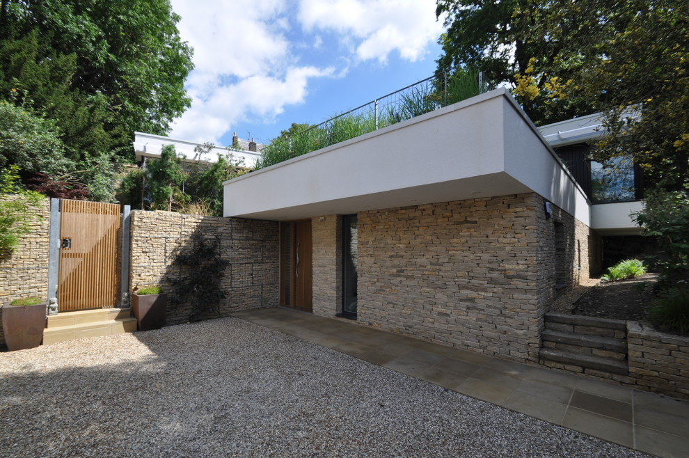 This is an example of a medium sized and white contemporary two floor brick house exterior in London.