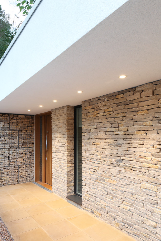 Photo of a medium sized and white contemporary two floor house exterior in London with stone cladding.