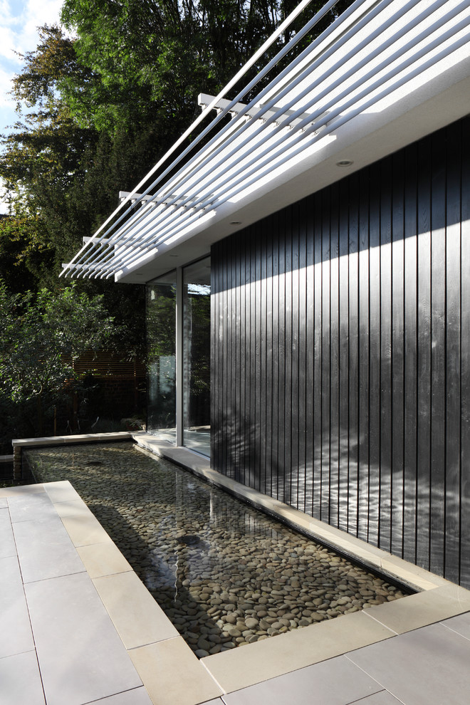Inspiration for a medium sized and white contemporary two floor house exterior in London with wood cladding.
