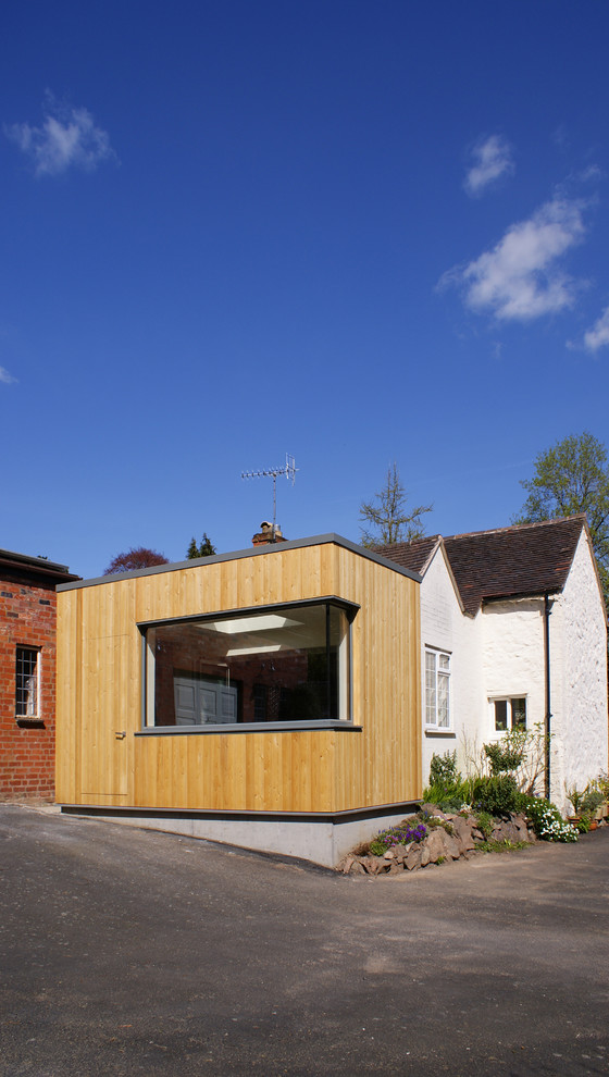 Réalisation d'une petite façade de maison beige minimaliste en bois de plain-pied avec un toit plat.