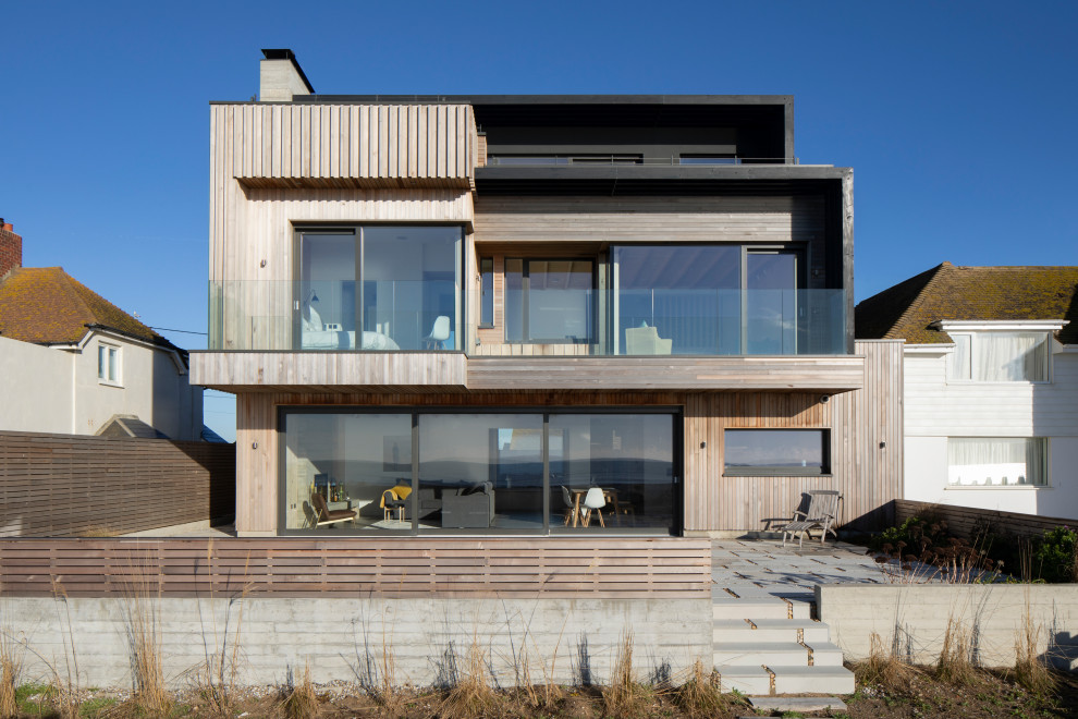 Idee per la villa beige moderna a tre piani con rivestimenti misti e tetto piano