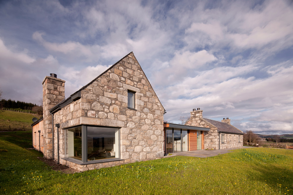 Идея дизайна: дом в стиле кантри с разными уровнями, облицовкой из камня и двускатной крышей