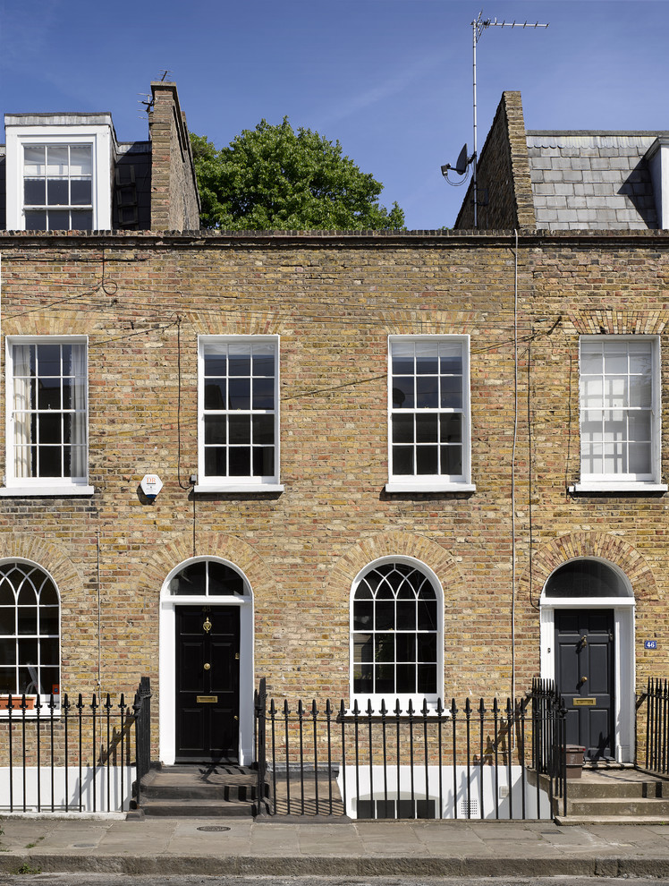 Zweistöckiges Klassisches Reihenhaus mit Backsteinfassade, brauner Fassadenfarbe und Flachdach in London