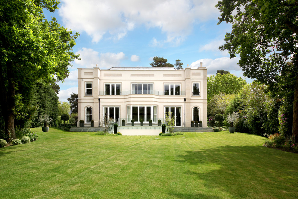 Huge elegant white three-story stucco flat roof photo in Surrey