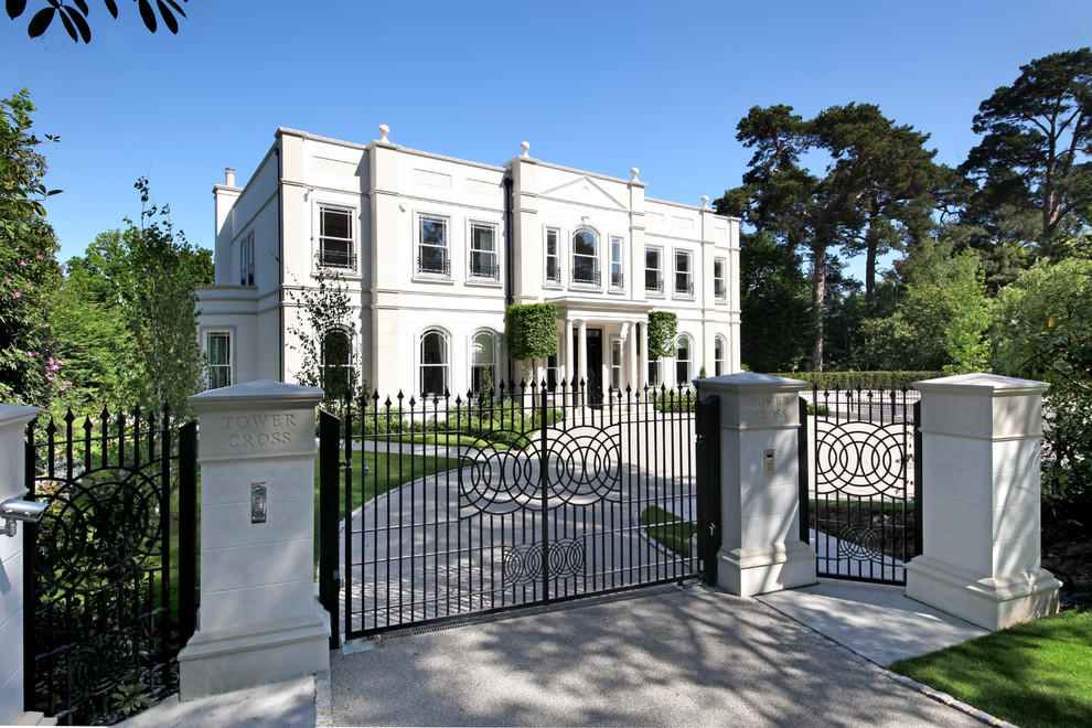 Immagine della facciata di una casa ampia bianca classica a tre piani con rivestimento in stucco e tetto piano