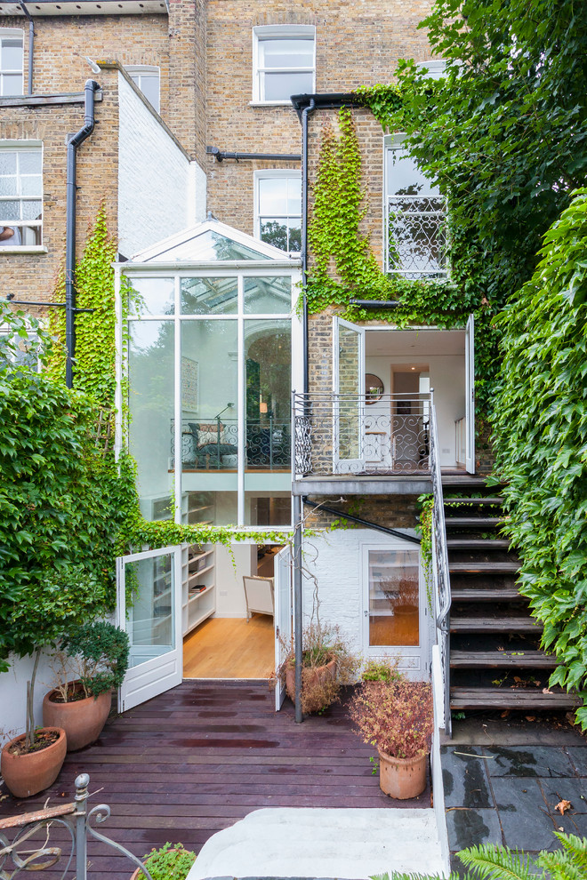 Brown classic brick house exterior in London with three floors.