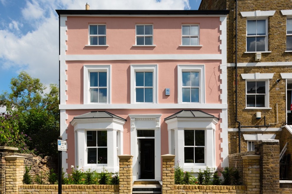 This is an example of a traditional house exterior in London with three floors, a flat roof and a pink house.