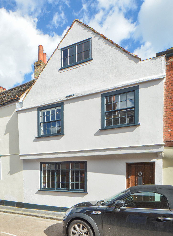 Medium sized and white farmhouse brick house exterior in Kent with three floors.