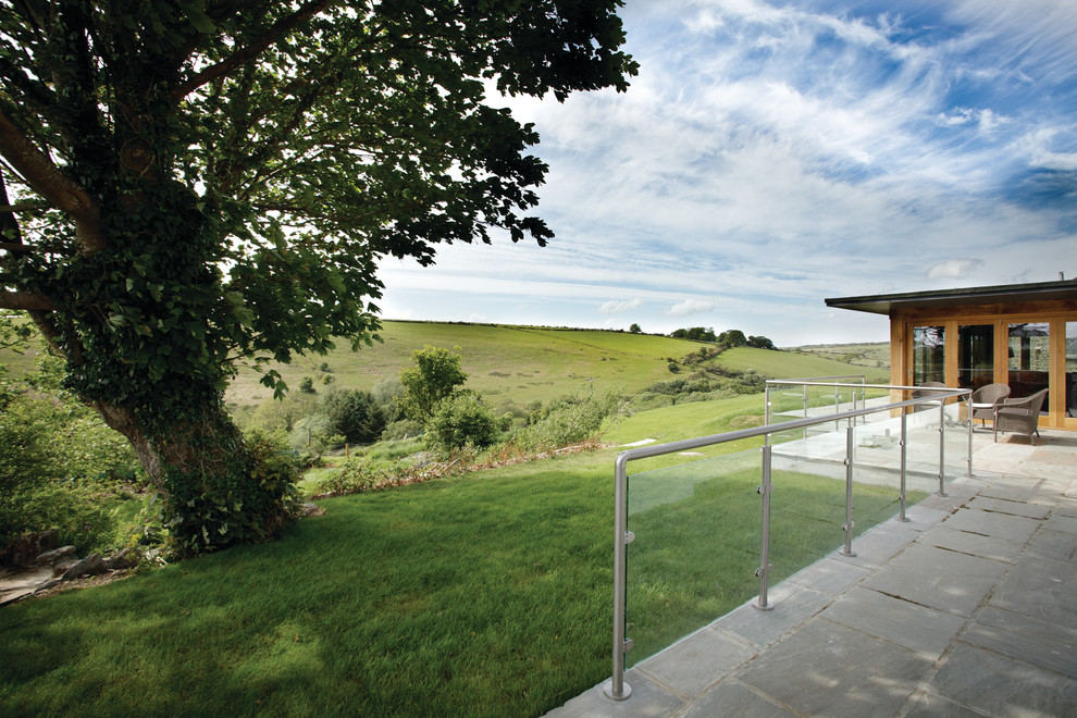 Photo of a contemporary house exterior in Devon with wood cladding.