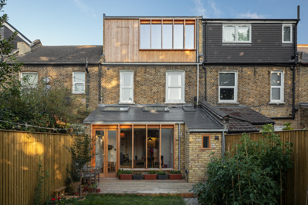 Contemporary house exterior in London with three floors and wood cladding.