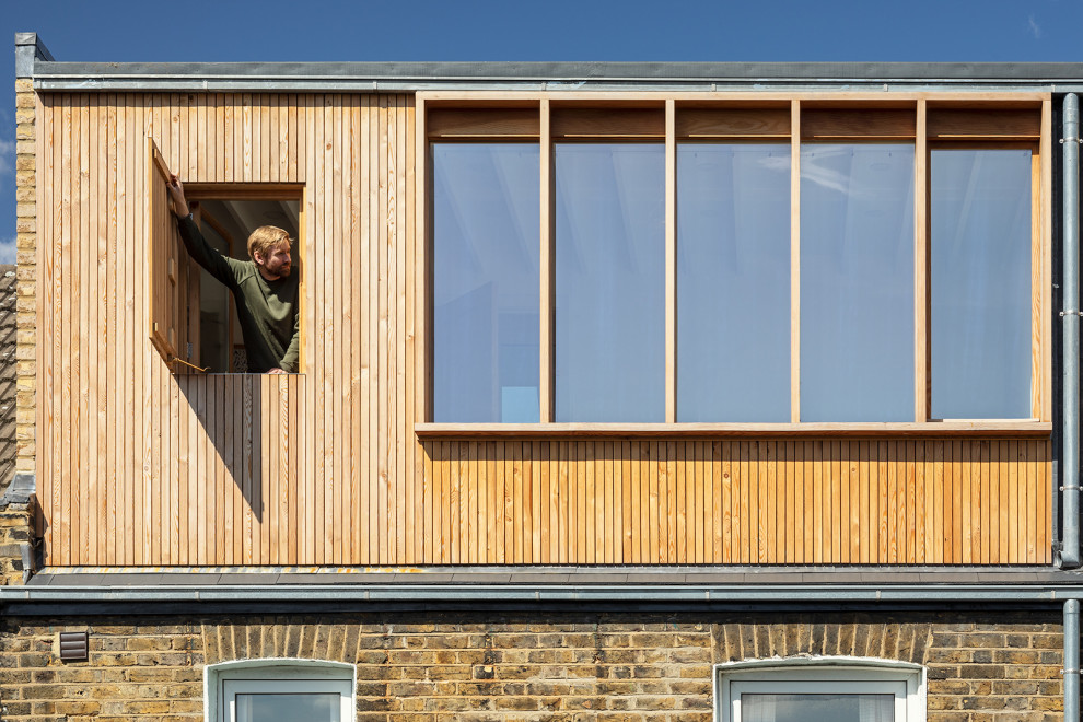 Photo of a contemporary house exterior in London with three floors and wood cladding.