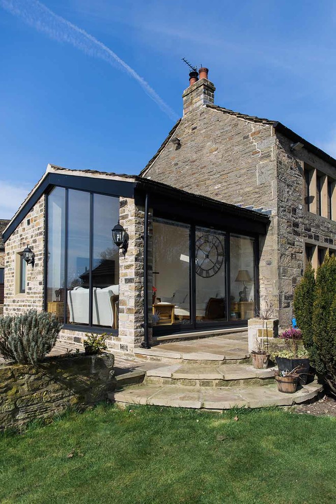 Country Haus mit Steinfassade, grauer Fassadenfarbe und Satteldach in Sonstige
