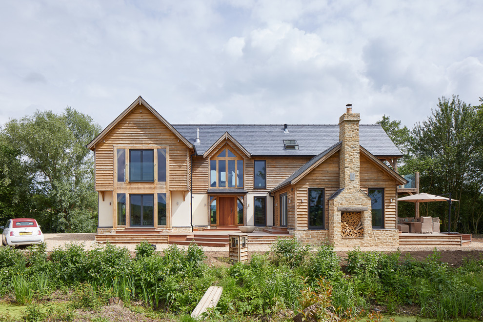 Idées déco pour une façade de maison beige campagne en bois à un étage avec un toit à croupette.