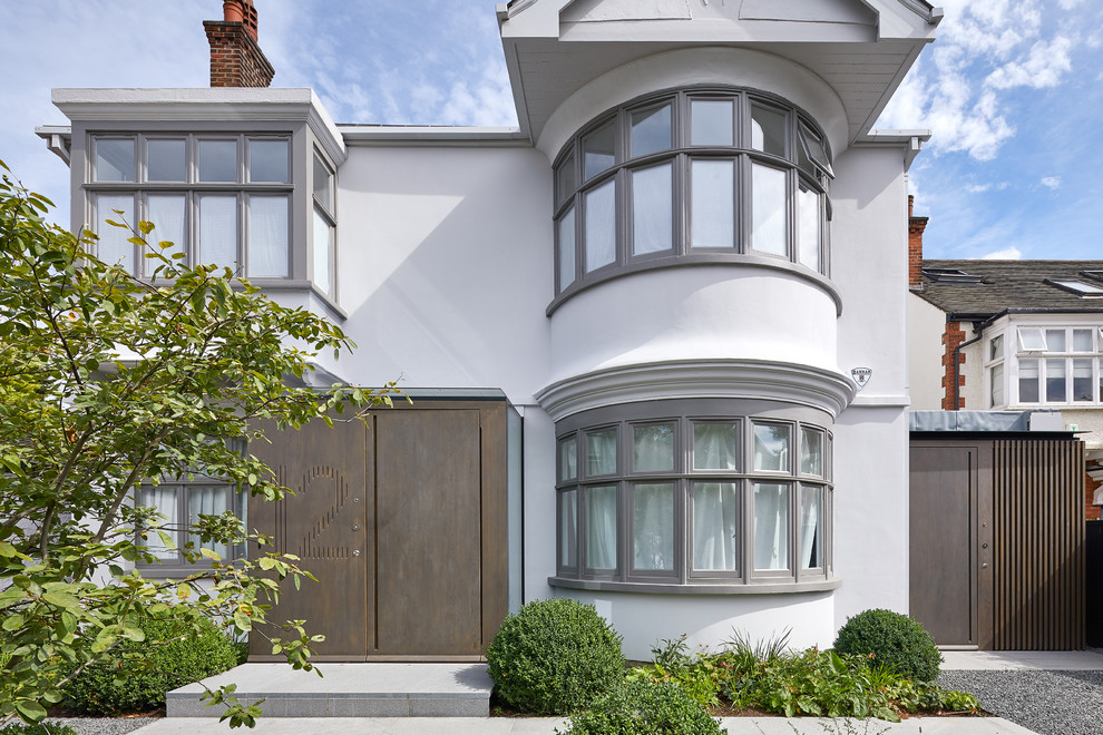 Photo of a white classic two floor render detached house in London.