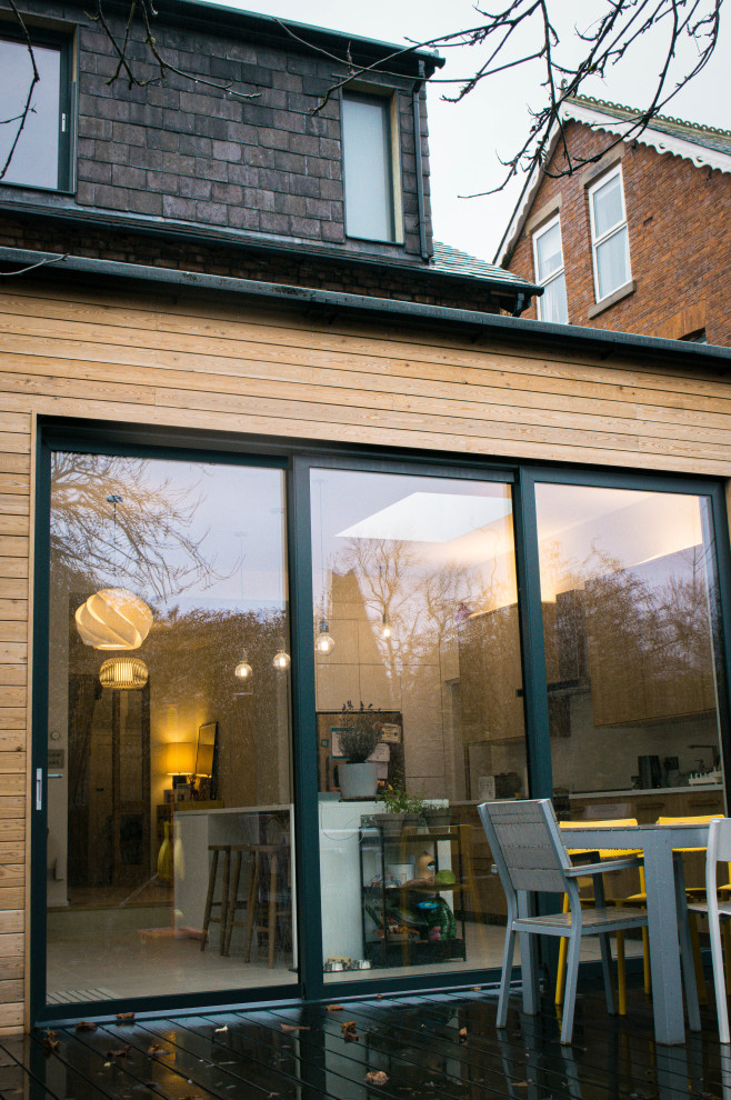 Design ideas for a medium sized and multi-coloured modern semi-detached house in Manchester with three floors, wood cladding, a flat roof and a mixed material roof.