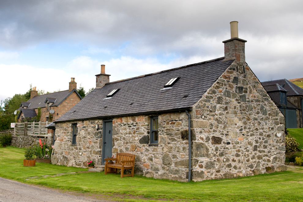 Foto de fachada de estilo de casa de campo de una planta con revestimiento de piedra y tejado a dos aguas