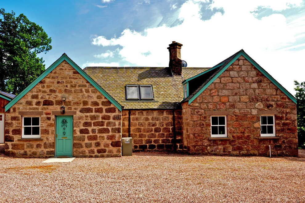 Idee per la facciata di una casa country con rivestimento in pietra e tetto a capanna
