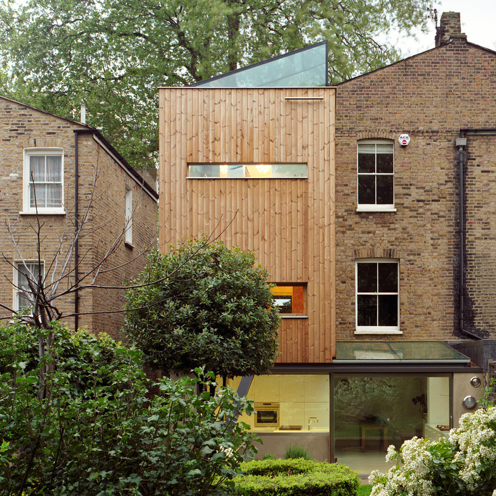 Immagine della facciata di una casa marrone contemporanea a tre piani con rivestimento in legno