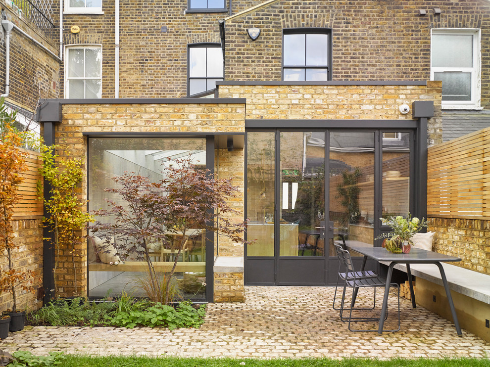 Inspiration for a contemporary three-story brick townhouse exterior remodel in London