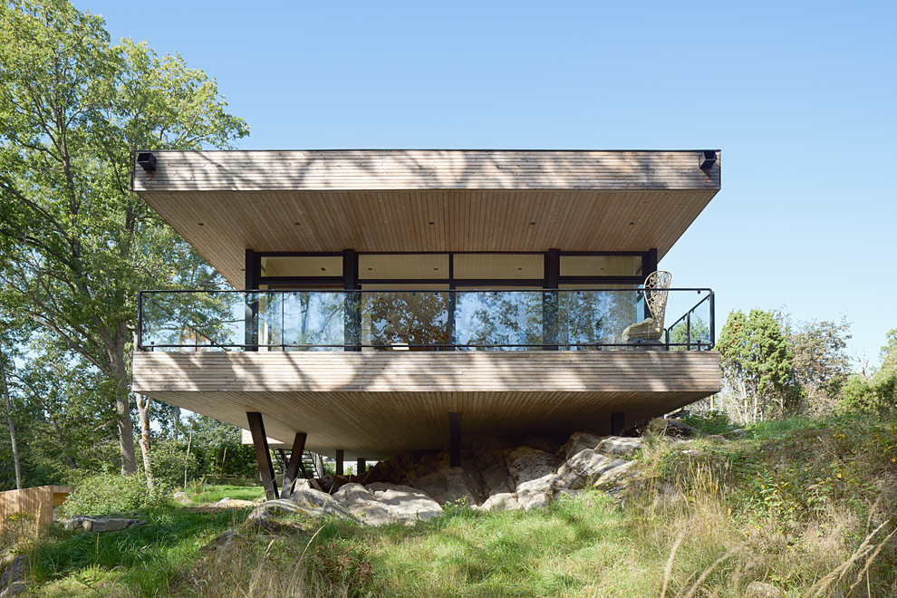 Réalisation d'une façade de maison beige minimaliste en bois de plain-pied avec un toit plat.