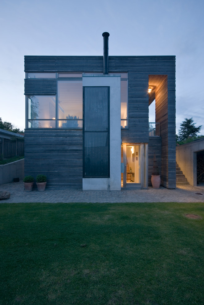На фото: двухэтажный, большой, коричневый дом в скандинавском стиле с комбинированной облицовкой и плоской крышей