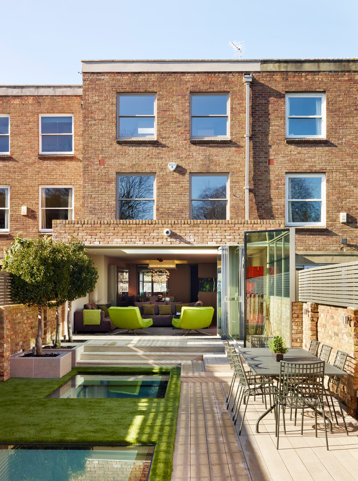 Inspiration for a contemporary brick house exterior in London with three floors and a flat roof.