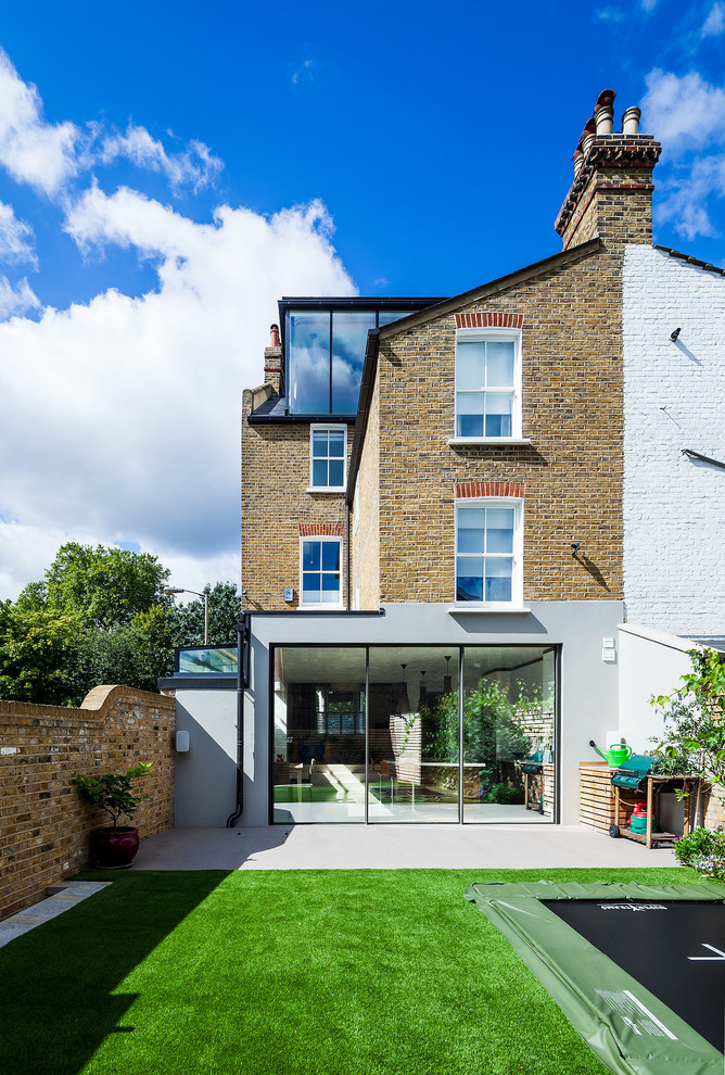 Dreistöckiges Klassisches Haus mit Backsteinfassade, brauner Fassadenfarbe und Satteldach in London