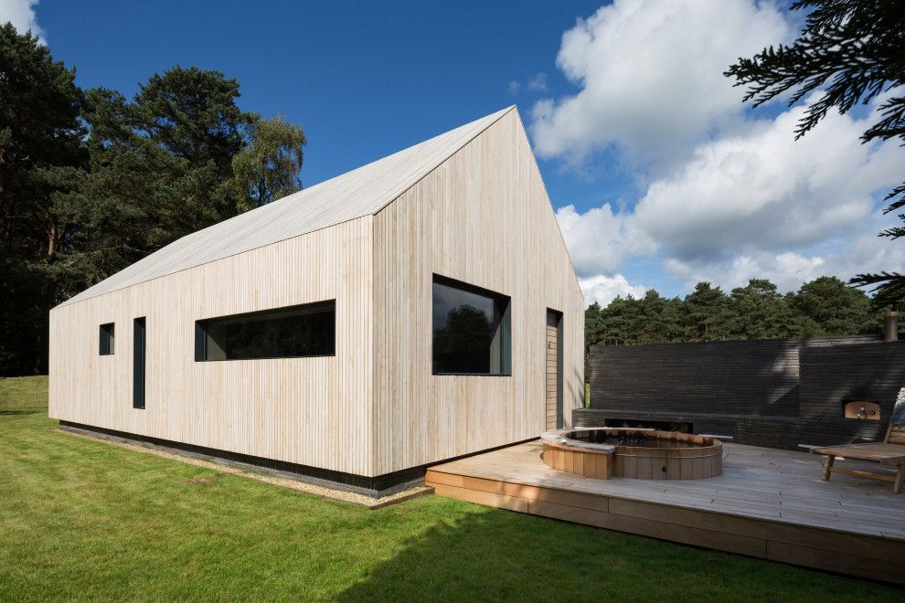 Стильный дизайн: одноэтажный, деревянный, бежевый частный загородный дом в современном стиле с двускатной крышей и металлической крышей - последний тренд