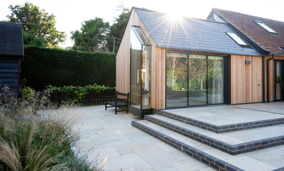 Imagen de fachada de casa bifamiliar minimalista con revestimiento de madera, tejado a dos aguas y tejado de teja de barro