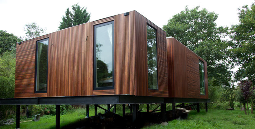 Medium sized and brown modern bungalow house exterior in London with wood cladding and a flat roof.
