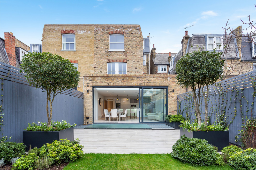 Inspiration for a large contemporary brick house exterior in London with three floors.
