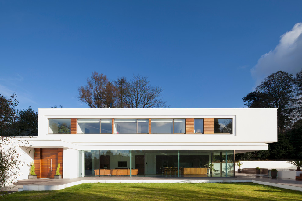 Идея дизайна: двухэтажный, белый дом в стиле модернизм с комбинированной облицовкой и плоской крышей
