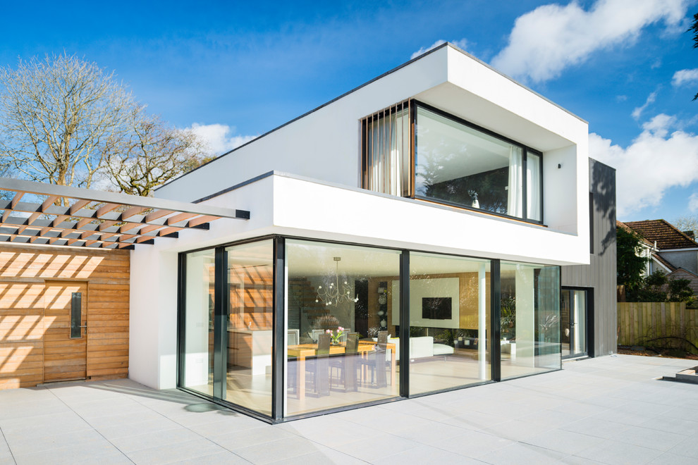 Inspiration for a modern two floor house exterior in Devon with a flat roof and mixed cladding.