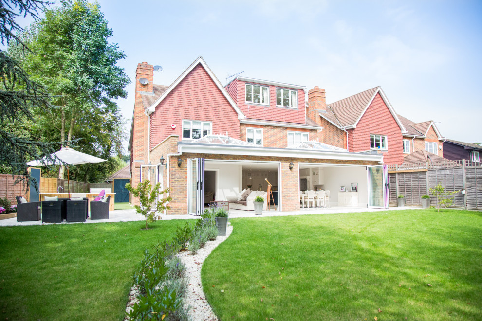 This is an example of a large and red modern brick detached house in Berkshire with three floors, a pitched roof and a tiled roof.
