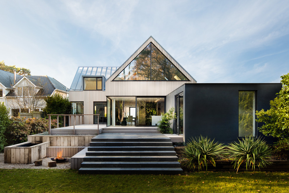 Ispirazione per la villa beige contemporanea a due piani di medie dimensioni con rivestimento in legno, tetto a capanna e copertura in metallo o lamiera