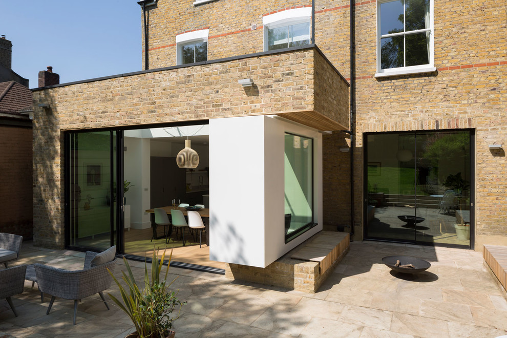 Dreistöckiges Modernes Einfamilienhaus mit Backsteinfassade, gelber Fassadenfarbe und Misch-Dachdeckung in London